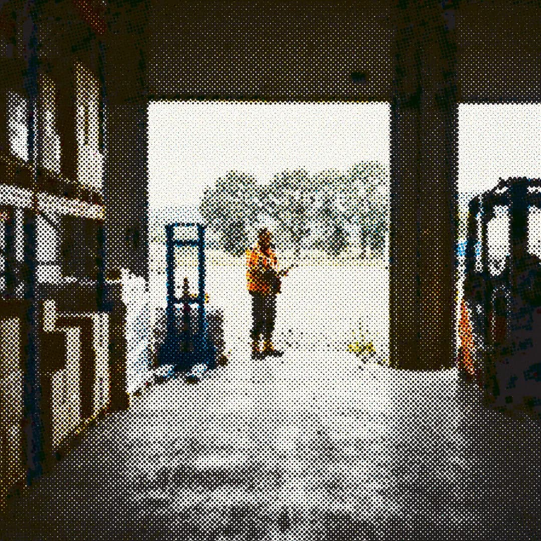Halftone image of a worker standing in a warehouse doorway